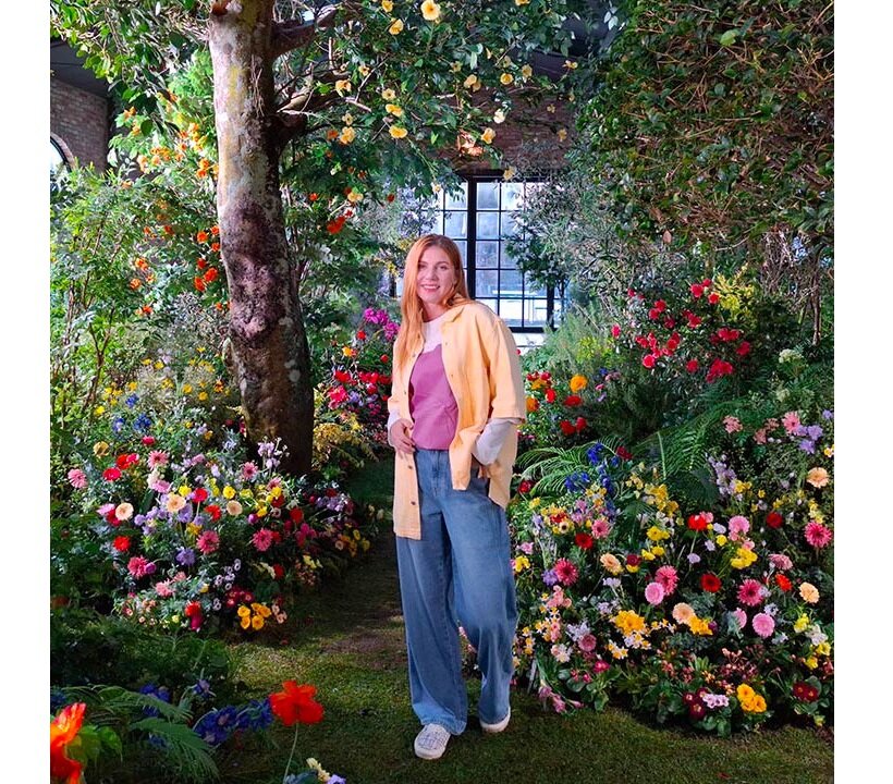 Smartfon Samsung Galaxy A55 5G 8/128GB różowy widok na zdjęcie kobiety stojącej w ogrodzie