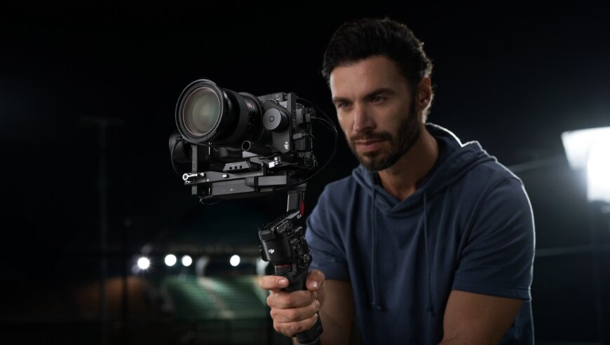 Stabilizator obrazu DJI RS 4 Combo czarny widok na mężczyznę trzymającego w dłoni stabilizator z zamontowaną kamerą