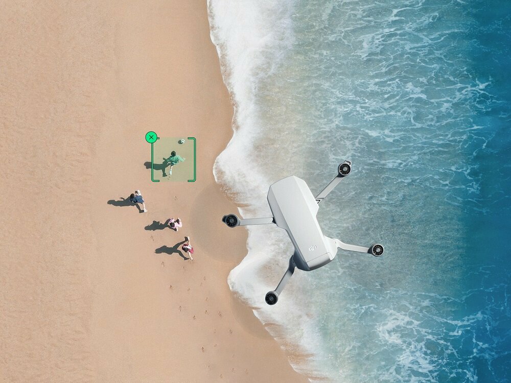 Dron DJI Mini 2 SE Single widok na drona od góry lecącego nad plażą w trakcie nagrywania grających w piłkę ludzi