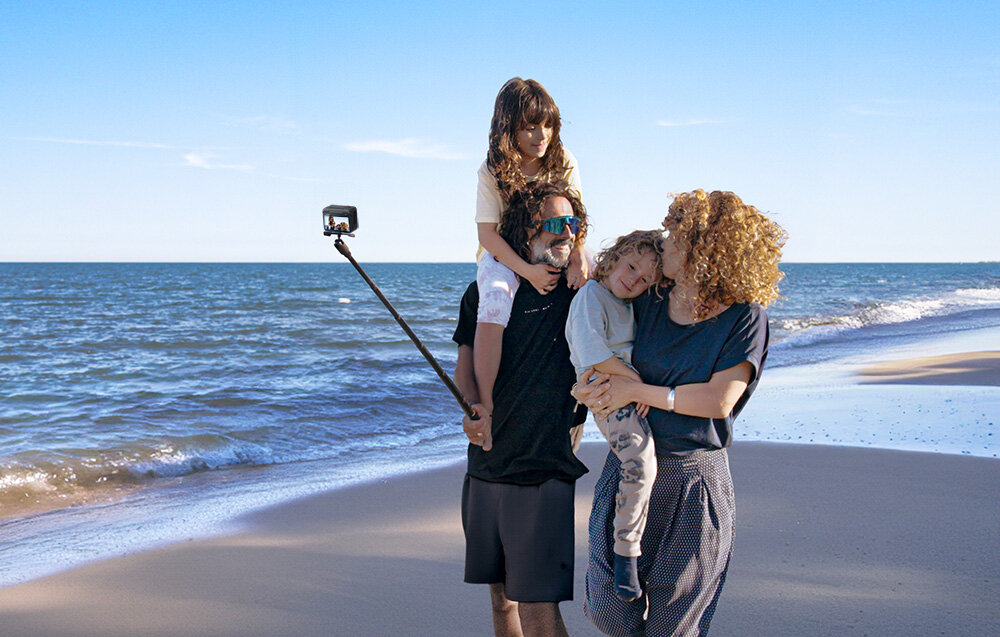 Kamera sportowa Insta360 GO 3S 128GB czarna widok na dwie dorosłe osoby trzymające dzieci na barkach na plaży