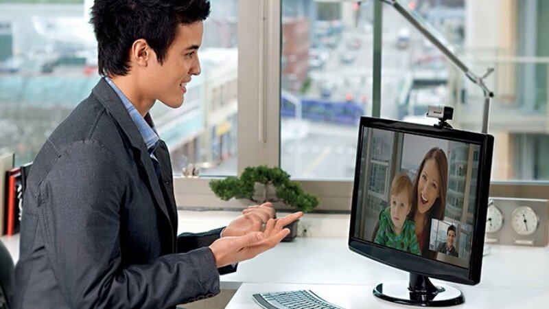 Kamera internetowa Microsoft LifeCam Studio 5WH-00002 srebrna z mężczyzną w biurze podczas rozmowy przez kamerę