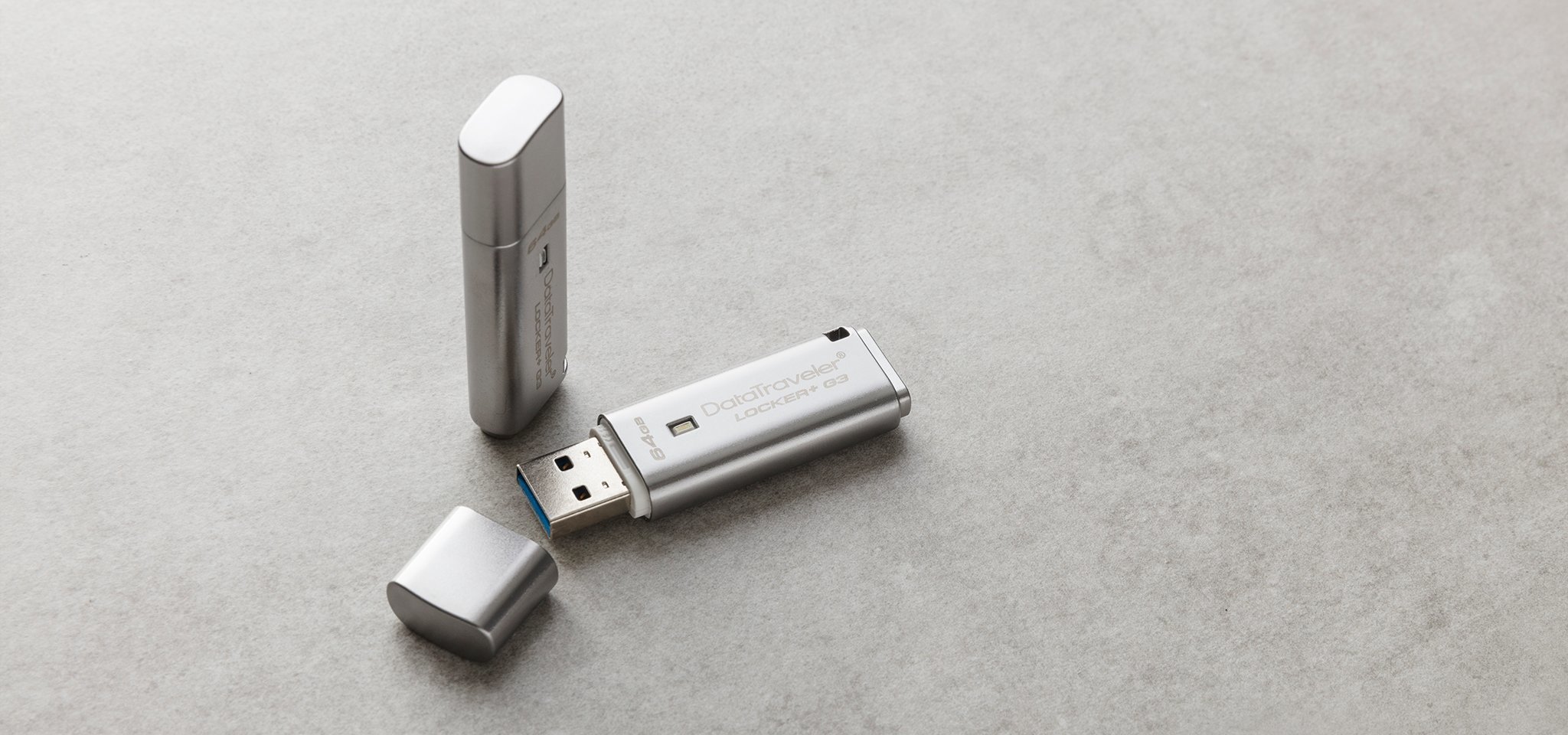 Pamięć Kingston 64GB DataTraveler Locker+ G3 (USB 3.0) 135MB/s DTLPG3/64GB szary widok od przodu na dwa produkty, jeden pendrive ze zdjętą osłoną portu