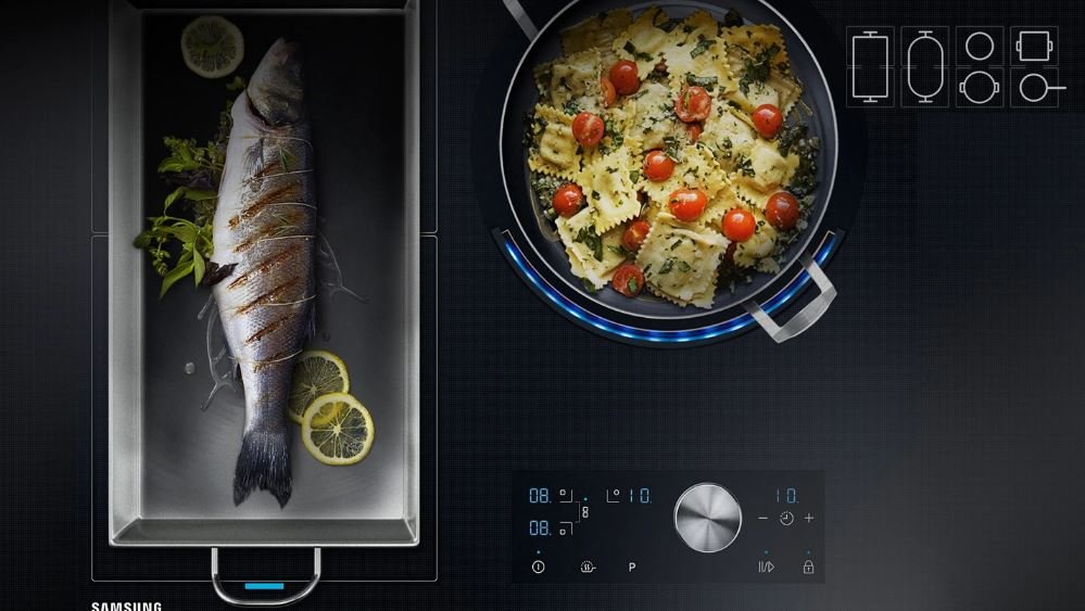 Płyta indukcyjna Samsung NZ63J9770EK  brytfanna z rybą i duża patelnia z makaronem na płycie