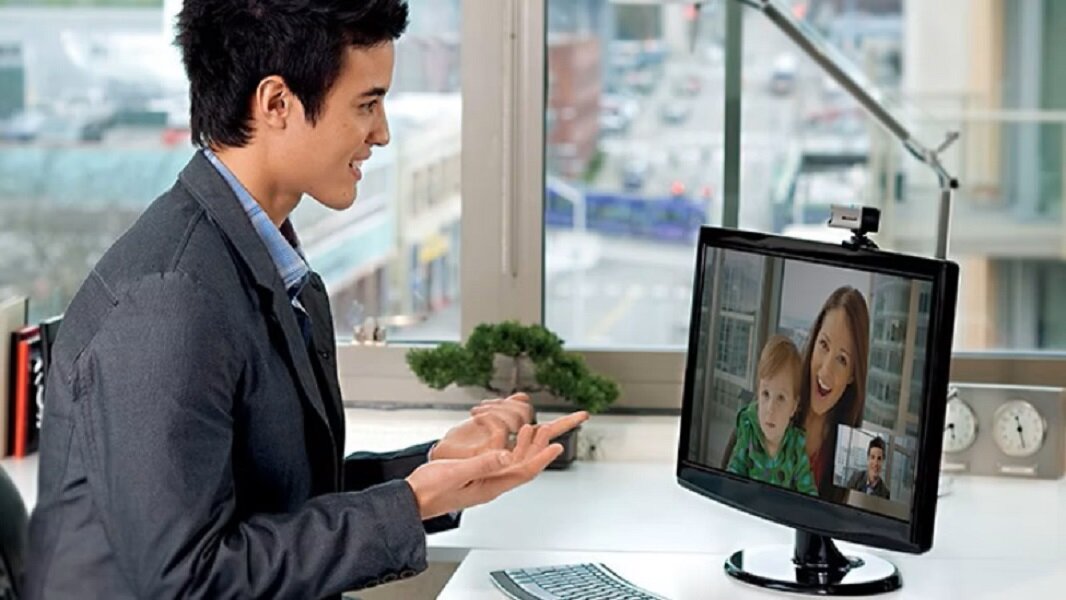 Kamera internetowa Microsoft LifeCam Studio Full HD z mężczyzną rozmawiającym przez kamerę w biurze